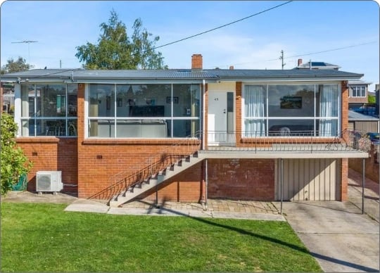 Brick residential property with a front lawn